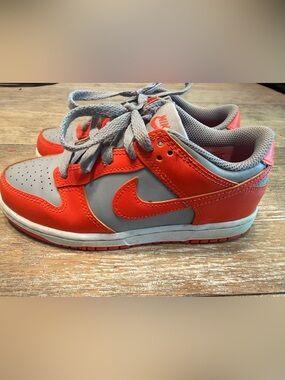 Nike Dunk Low shoes in a "Cement Grey/Team Orange" little kid